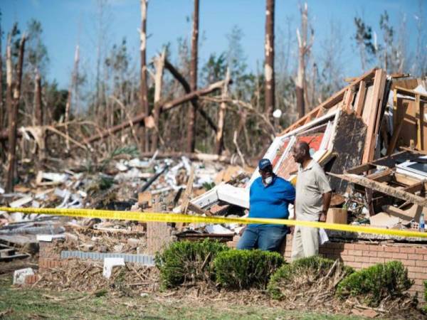 Dua lelaki di hadapan sebuah rumah yang musnah akibat dibadai puting beliung di Nixville, Carolina Selatan. - Foto AFP