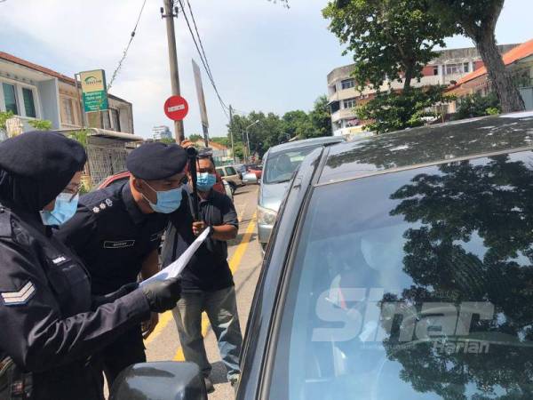 Soffian sedang menyoal salah seorang pemandu dalam sekatan jalan raya di Jalan Perak di sini hari ini.