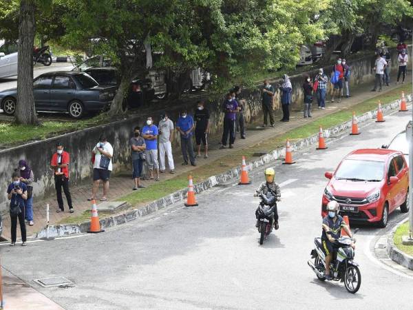 Orang ramai mematuhi arahan Perintah Kawalan Pergerakan (PKP) dengan melakukan penjarakan sosial semasa menunggu giliran untuk memasuki pasar. - Foto Bernama