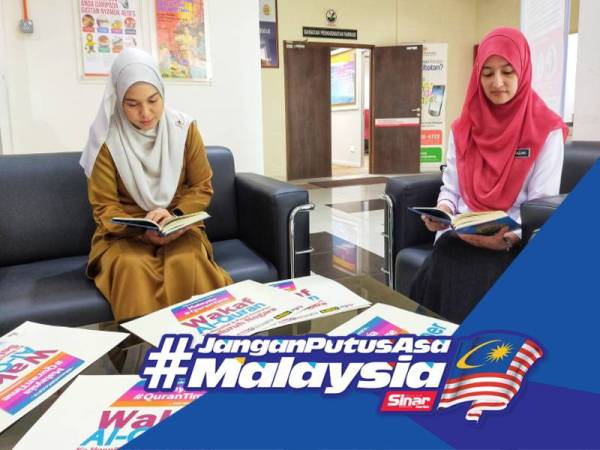 Timbalan Pengarah Kesihatan negeri (Keselamatan dan Kualiti Makanan) Norazlina Omar (kanan) bersama Penolong Pegawai Tadbir bahagian Pengurusan, Naimah Yunus meluangkan masa membaca al-Quran di bangunan JKN Perlis di sini hari ini.