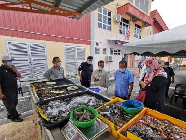 Raja Kahalid (dua dari kanan) meninjau Pasar Segar Terkawal di Kompleks LKIM Kuala Kurau, Parit Buntar semalam.