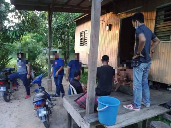 Sekumpulan lelaki ini yang sedang melepak di salah sebuah rumah penduduk kampung di Paka, di sini ditahan dalam operasi bersepadu PKP fasa 3, semalam. - Foto FB IPD Dungun