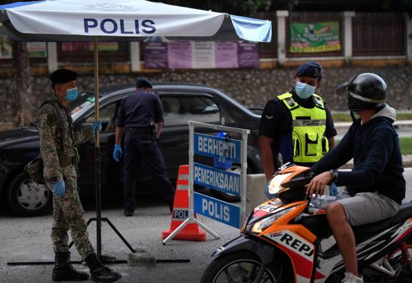 Anggota polis dan Angkatan Tentera Malaysia (ATM) memeriksa dan menyoal orang awam yang melalui sebuah sekatan jalan raya sekitar ibu kota. Foto: Bernama