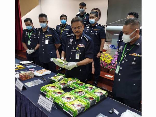 R Sundralingam (tengah) menunjukkan bungkusan dadah yang berjaya dirampas dalam serbuan sekitar Lembah Klang Rabu lalu.