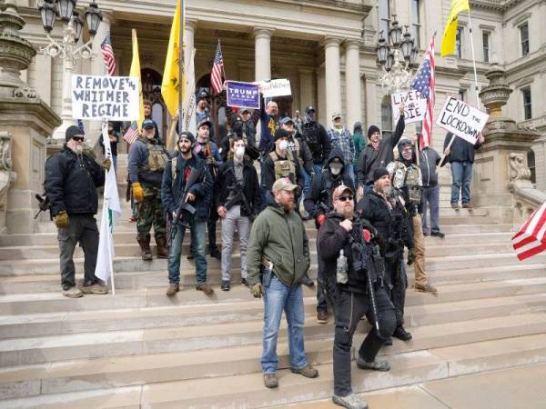 Penunjuk perasaan membawa raifal ketika berkumpul di bangunan Capitol di Lansing bagi mendesak perintah berkurung di Michigan ditarik balik. - AFP