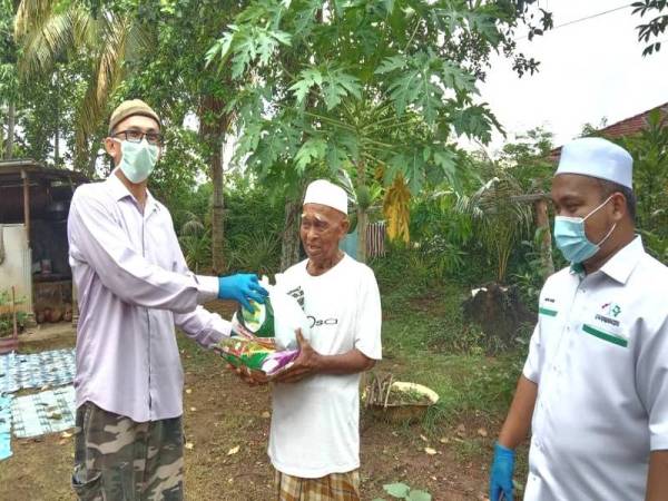 Azhar (kiri) menyampaikan sumbangan kepada mangsa ribut yang terjejas semalam.