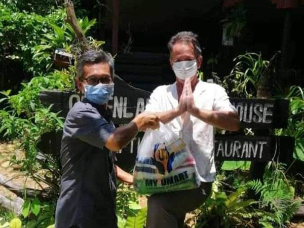 Abdul Jalil (kiri) menyerahkan sumbangan makanan kepada Thomas Hanry di sebuah resort di Kuala Tahan semalam.