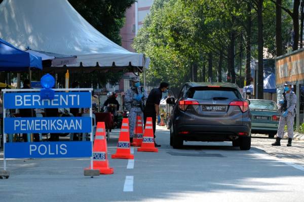 Anggota polis bersama anggota Tentera Laut Diraja Malaysia (TLDM) memeriksa kenderaan dalam sebuah sekatan jalan raya. -Foto Bernama