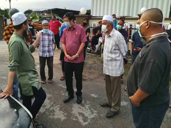 Kok Yew (tiga dari kanan) dan Ustaz Ebit (kiri) ketika berada di rumah usang dihuni Ishak sekeluarga di Lorong Gedebang sebelum keluarga itu dipindahkan semalam.