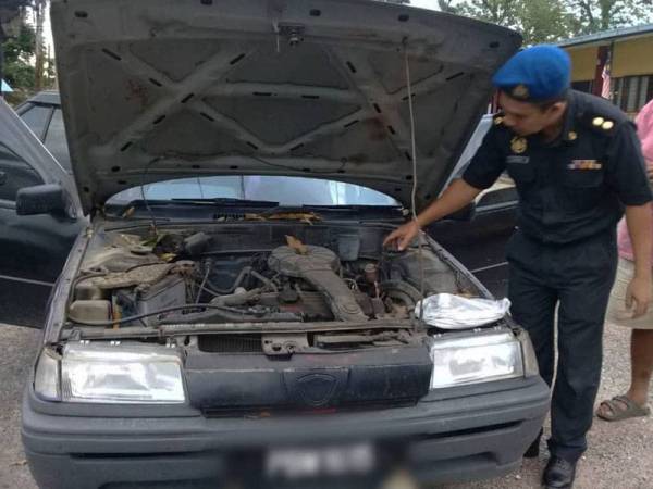 Azizi kanan menunjukkan kereta yang dirampas.