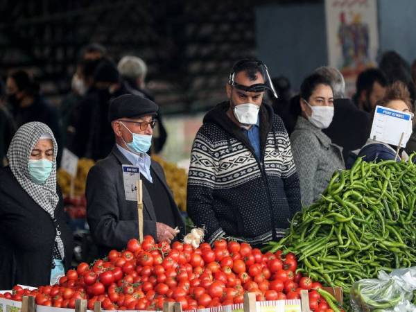 Rakyat Turki memakai topeng muka ketika membeli persiapan Ramadan di sebuah pasar di Ankara.