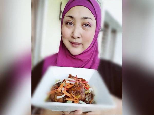 Dayang Kartini menunjukkan hidangan ayam masak lada hitam hasil air tangannya.