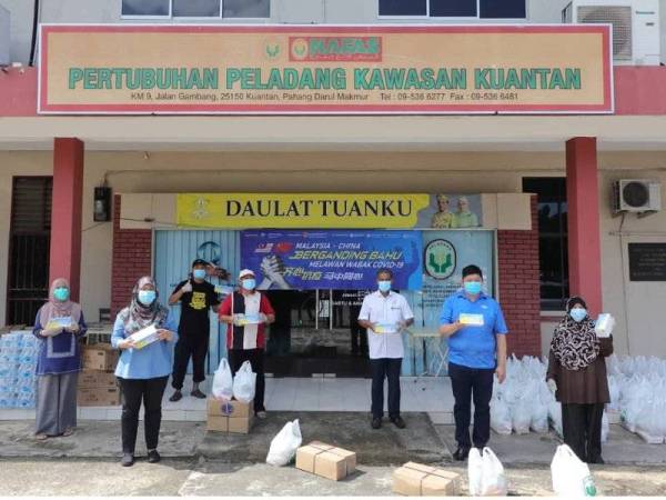 Ching Fung (dua dari kanan) menyerahkan sumbangan keperluan harian kepada pihak PPK Kuantan.