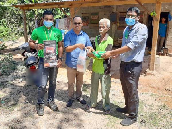 Devanathan (kanan) turun padang menyampaikan sumbangan fasa ketiga Econsave Pokok Sena kepada 30 keluarga di Mukim Gajah Mati baru-baru ini.