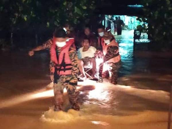 Bomba membantu memindahkan mangsa banjir ke PPS Surau Sungai Kuning, Selama malam tadi. - Foto JBPM