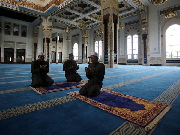 Imam Masjid Sri Sendayan Syed Abdul Waahid Qusyairi Syed Ahmad Johari (tengah) mengaminkan doa selepas menunaikan solat Zohor menggantikan solat Jumaat. - Foto Bernama