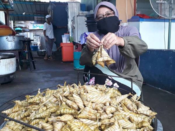 Che Non menunjukkan ketupat palas yang baru sahaja dimasak.