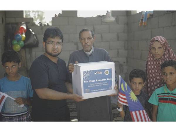 Nadir (dua dari kiri) menyampaikan bantuan pek iftar kepada orang miskin di Gaza.