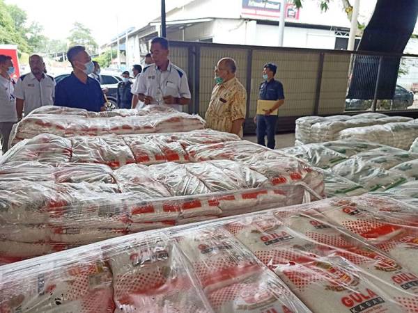 Pengarah Urusan Golden Hp Agency, Ng Kim Kee memberi penerangan mengenai bekalan makanan kepada Rosol (tengah) sewaktu membuat tinjauan bekalan asas di pusat pemborong miliknya di Indera Mahkota hari ini.