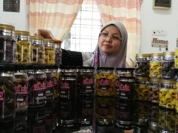 Munirah bersama sebahagian daripada kuih raya yang dihasilkannya.