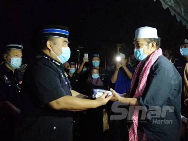 Fadzil menyerahkan Panji Sang Saka Biru kepada bapa Allahyarham, Muhammad Ismail.