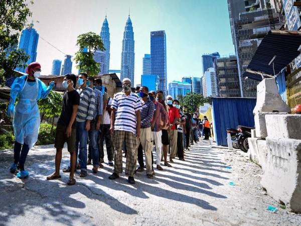 Pekerja warga asing dikumpulkan di sebuah tapak pembinaan di Kampong Bharu, Kuala Lumpur baru-baru ini untuk menjalani prosedur saringan Covid-19.