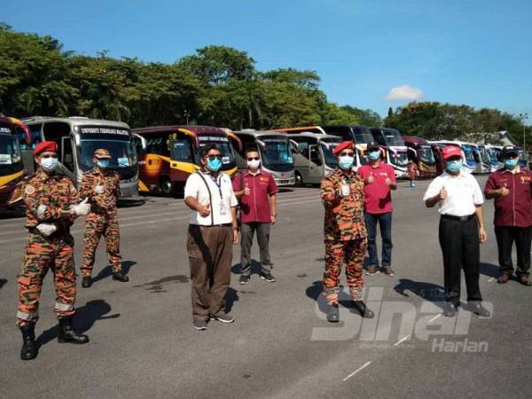 Wahid Omar (depan, kanan) dan Yahaya Madis (dapan, dua dari kanan) bersama kakitangan UTM dan anggota bomba selepas program khidmat sanitasi 33 bas Kementerian Pengajian Tinggi (KPT) di UTM, Skudai, Johor Bahru, hari ini.