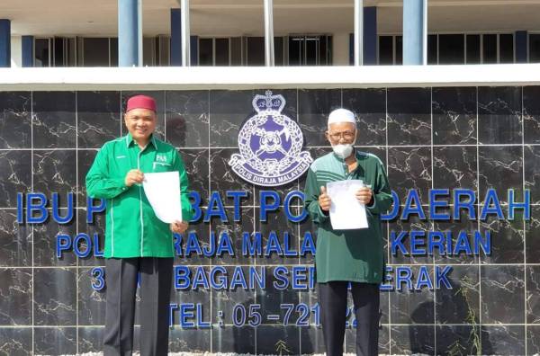 Khalil Idham (kiri) bersama aktivis Ummah, Termizi Mohamad membuat laporan polis di IPD Kerian, di sini, hari ini.