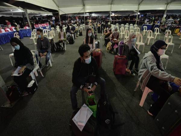 Pelajar IPT menunggu giliran sebelum menaiki bas ketika proses penghantaran 417 pelajar IPT yang berasal dari zon timur di Dataran UTM malam tadi. -Foto Bernama