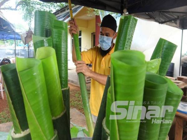 Nik Suhaimy ketika menyiapkan lemang yang ditempah pelanggan.