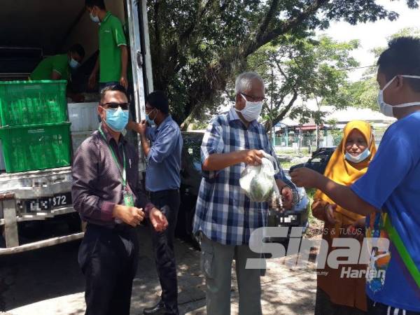 Mahfuz (tiga dari kanan) menyerahkan sumbangan Econsave Cash and Carry di Pekan Pokok Sena kepada 400 penerima hari ini.