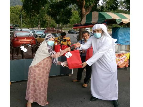 Sheikh Abdul Rahman mengedarkan bungkusan iftar kepada penduduk di Ampang, semalam.