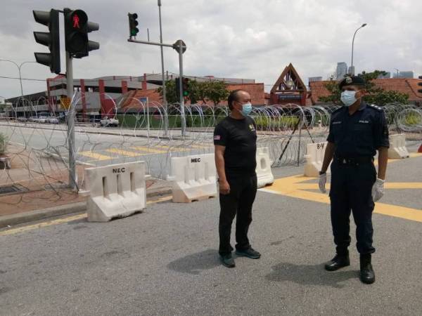 Nik Ezanee (kanan) meninjau PKPD di kawasan Pasar Jalan Othman, hari ini.