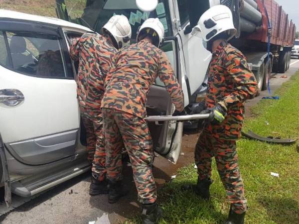 Anggota bomba berusaha mengeluarkan mangsa tersepit dalam pacuan empat roda selepas bertembung dengan sebuah treler di Lebuh Raya Senai-Desaru, Kota Tinggi, Johor hari ini.