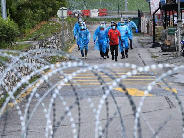 Petugas Kesihatan Kementerian Kesihatan Malaysia (KKM) dilihat mengiringi seorang penghuni dipercayai warga asing untuk ke pusat saringan bagi menjalani saringan Covid-19 ketika tinjauan di sekitar kawasan Pasar Jalan Othman semalam. - Foto Bernama