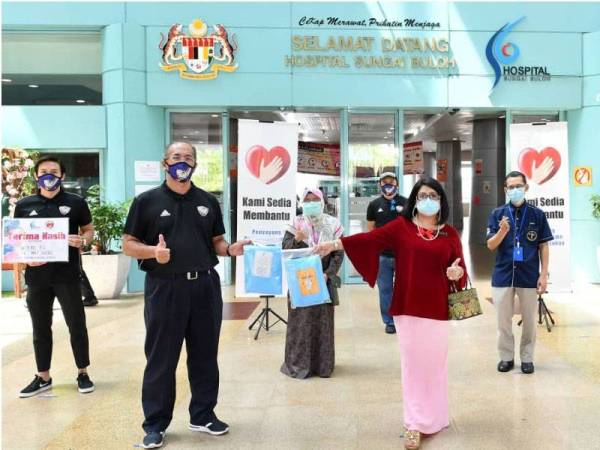 Mustaza (kiri) menyerahkan sumbangan kepada Dr Kuldip Kaur dalam satu majlis ringkas di Hospital Sungai Buloh hari ini. (GAMBAR UTAMA)