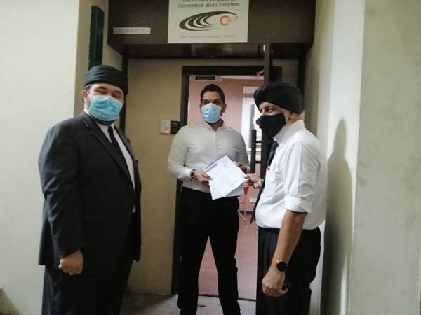 Rejinder Singh (kanan) dan Nasser (kiri) menyerahkan notis kepada wakil C4 berhubung tuntutan fitnah di Pejabat C4 di Avenue 8, Petaling Jaya hari ini.