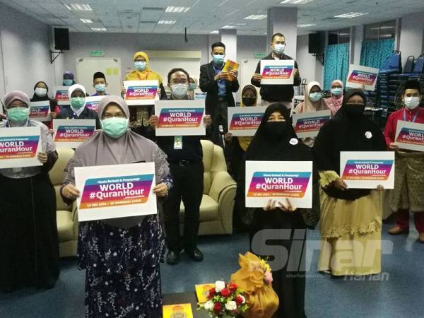 Dr Narimah (depan, kiri) dan Noor Mazlina (depan, kanan) bersama peserta World #QuranHour menunjukkan plakad program tersebut selepas menjayakannya di Hospital Taiping di sini hari ini.