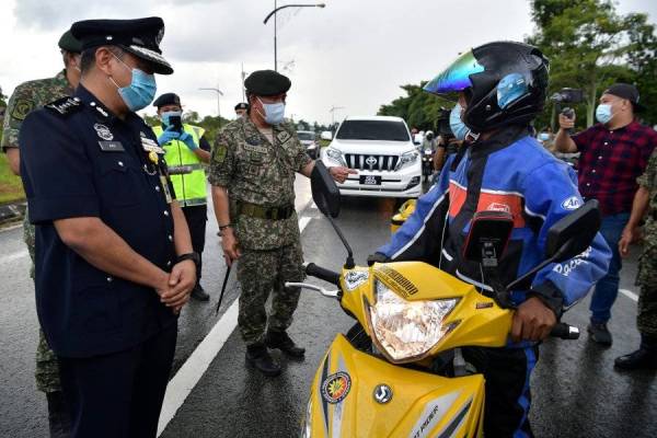 Ahmad Hasbullah memeriksa penunggang motosikal pada Sekatan Jalan Raya (SJR) di hadapan Lapangan Terbang Antarabangsa Kuching (LTAK) pada lawatan ke lokasi OP Penawar di bawah Kawasan Tanggungjawab (KTJ) Pemerintahan Medan Timur Tentera Darat (PMTTD). - Foto Bernama