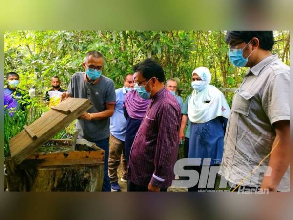 Che Abdullah (dua dari kanan) mendengar penerangan yang disampaikan oleh Azman (kiri) berkenaan kelulut peliharaannya.