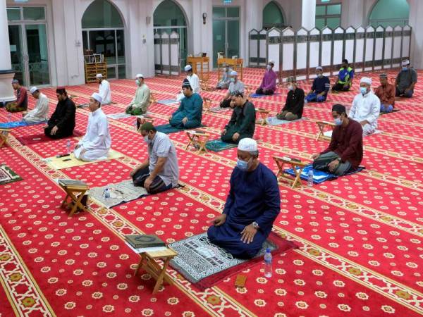 Jemaah menunaikan solat sunat tarawih dalam norma baharu apabila saf di jarakkan satu meter antara satu sama lain selain memakai penutup hidung dan muka semasa PKPB bagi mengekang penularan wabak Covid-19 di Masjid Mahmoodiah di Presint 18 malam tadi. - Foto Bernama