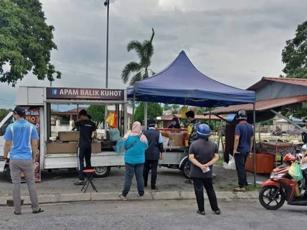 Orang ramai mengambil kesempatan mendapatkan apam balik percuma sempena Hari Guru dengan masing-masing menjaga penjarakan sosial seperti ditetapkan. - Foto Apam Balik Kuhot