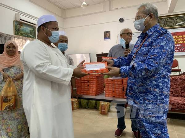 Annuar (kanan) menyampaikan sumbangan kepada imam yang diraikan dalam satu majlis di Darul Saodah, Kampung Chengal hari ini.