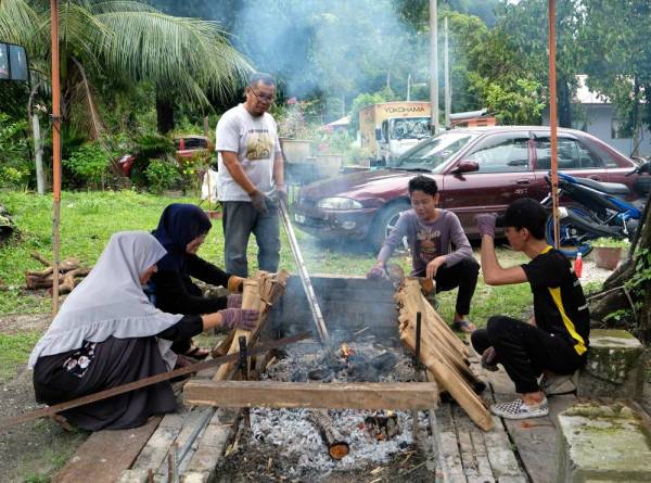 GOPENG, 17 Mei -- Pembuat kelamai, Haris Fadilah Shaharudin, 50,(tiga,kiri) bersama keluarganya membakar Kelamai di rumahnya di Kampung Gunung Mesah Hilir. -Foto Bernama