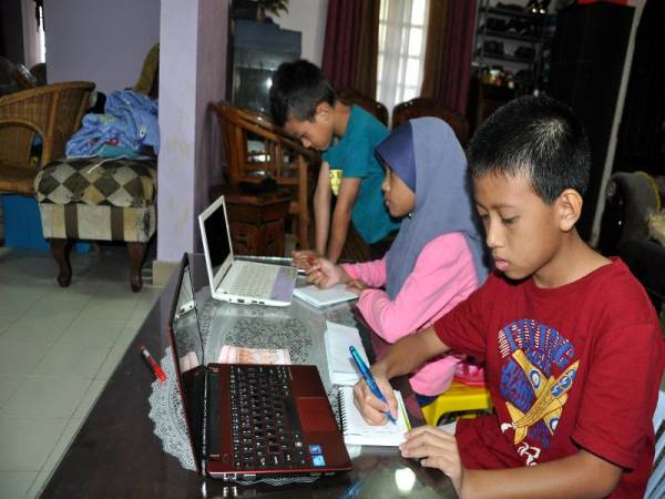 Tiga beradik, Mohd Khalish Aqeel Azizi, 13, (kanan), Arisa Yasmin, 9, (tengah) dan Mohd Khaleef Azeem, 7, (kiri) tekun mengikuti rancangan TV Pendidikan di rumah mereka di Kampung Gaung, Jertih, Terengganu sebagai normal baharu pembela­jaran dalam talian sepanjang PKP. -Foto Bernama