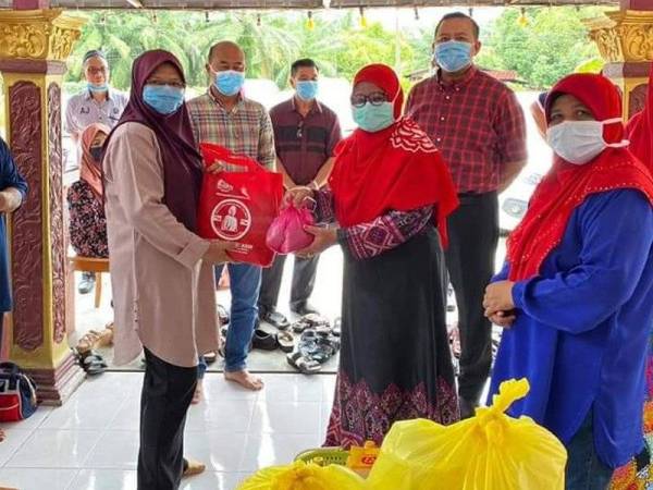 Rizam (belakang dua dari kanan) bergambar pada Program Memasak Bubur Lambuk Wanita UMNO Peringkat DUN Sabak di sini hari ini.