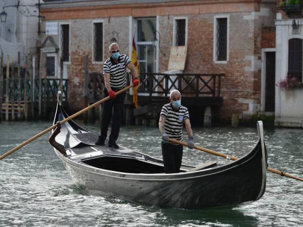 Pengendali gondola kembali bertugas hari ini selepas 'lockdown' di Itali ditarik balik. - Foto AFP