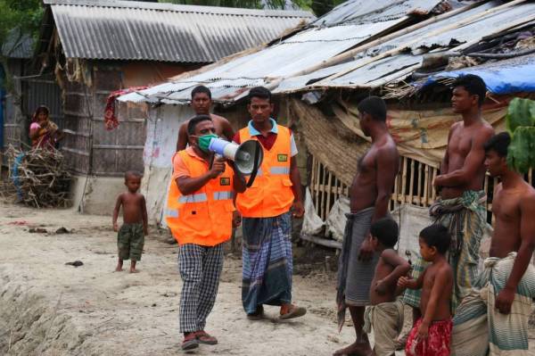 Seorang sukarelawan Program Kesiapsiagaan Taufan (CPP) menggunakan megafon untuk mendesak penduduk berpindah ke tempat perlindungan susulan ancaman taufan Amphan di Khulna, Bangladesh. 