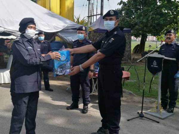 Surina menyampaikan sumbangan kuih raya kepada petugas barisan hadapan di SJR di Ulu Pauh, hari ini.