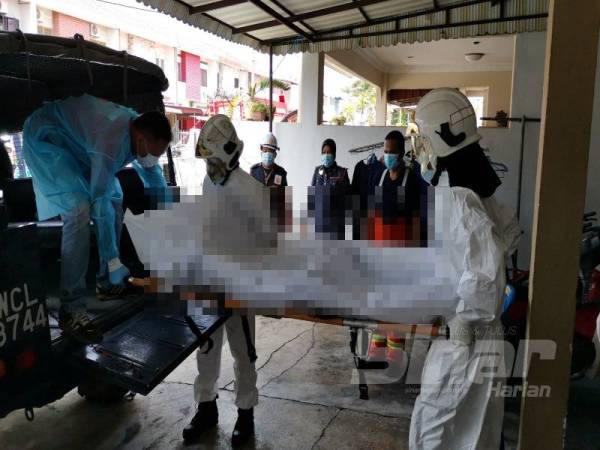 Anggota bomba mengangkat mayat mangsa yang melecur dalam kebakaran rumah di Lebuh Perajurit 3, Taman Ipoh Timur hari ini. 